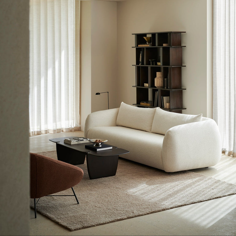 Ethnicraft Figur three-seat sofa in off-white Chalk fabric beside a dark coffee table in a sunlit living room
