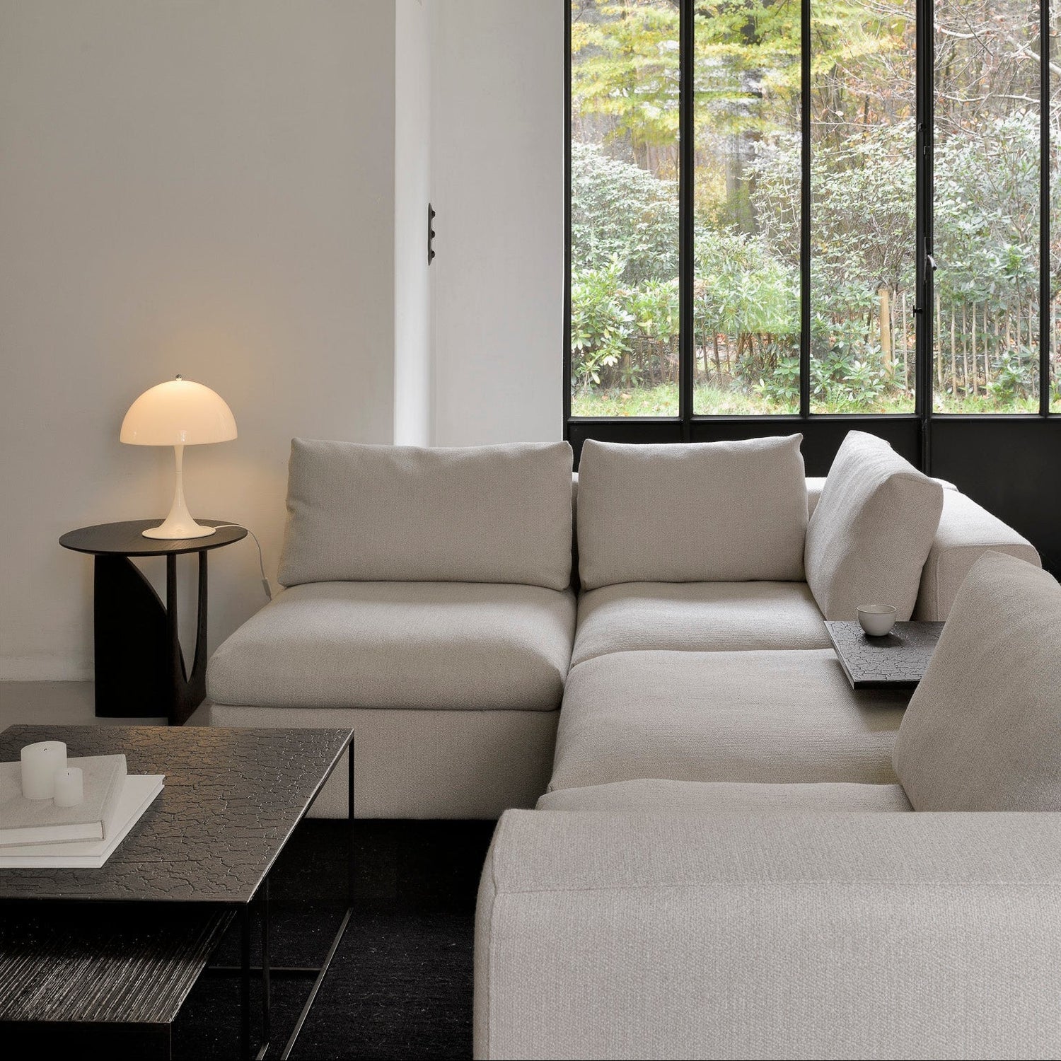 Ethnicraft Mellow modular sofa in a living room, its FSC-certified solid wood frame paired with reconfigurable, deep seat modules in soft neutral upholstery.