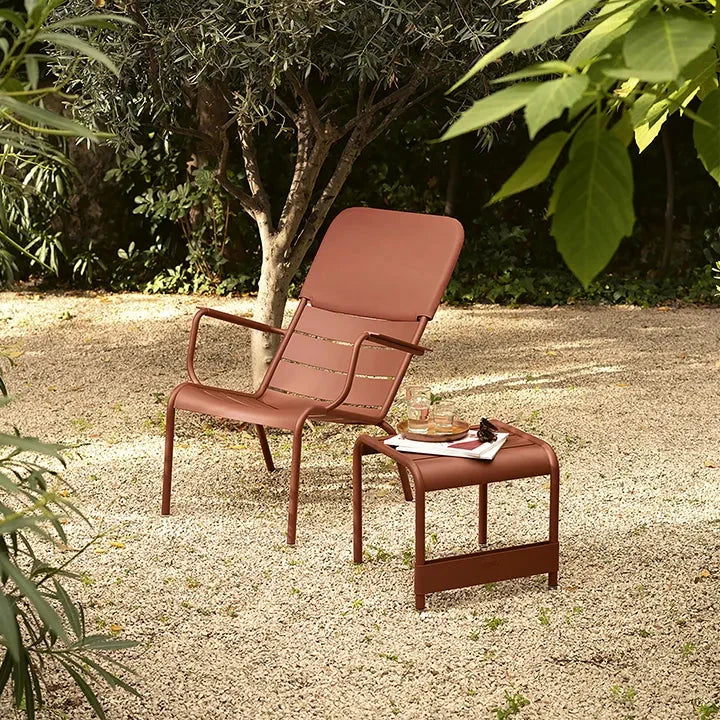 Fermob Luxembourg low armchair in powder-coated steel and aluminium, shown on a sunlit outdoor terrace