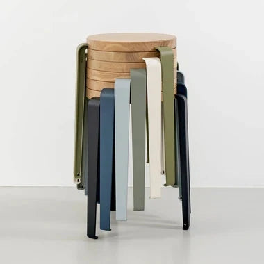 Tiptoe LOU stool with a round solid oak seat and four powder-coated steel legs that unscrew for moving, shown in a bright apartment.
