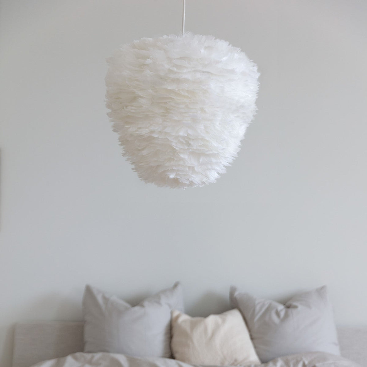 UMAGE Eos Evia pendant lamp in white goose feathers hanging in a Scandinavian living room