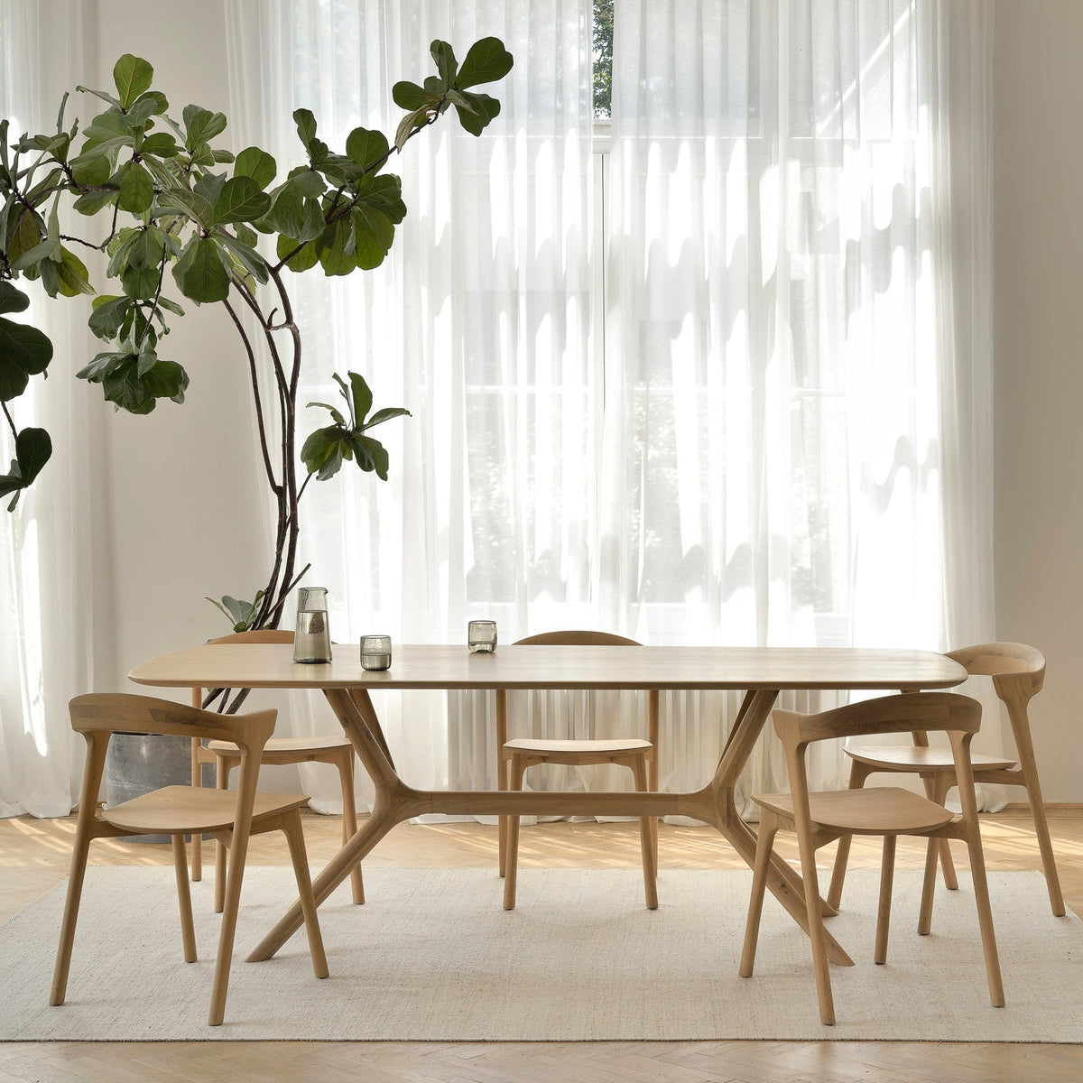 Ethnicraft X dining table in solid oak with oak Bok dining chairs in a bright dining room