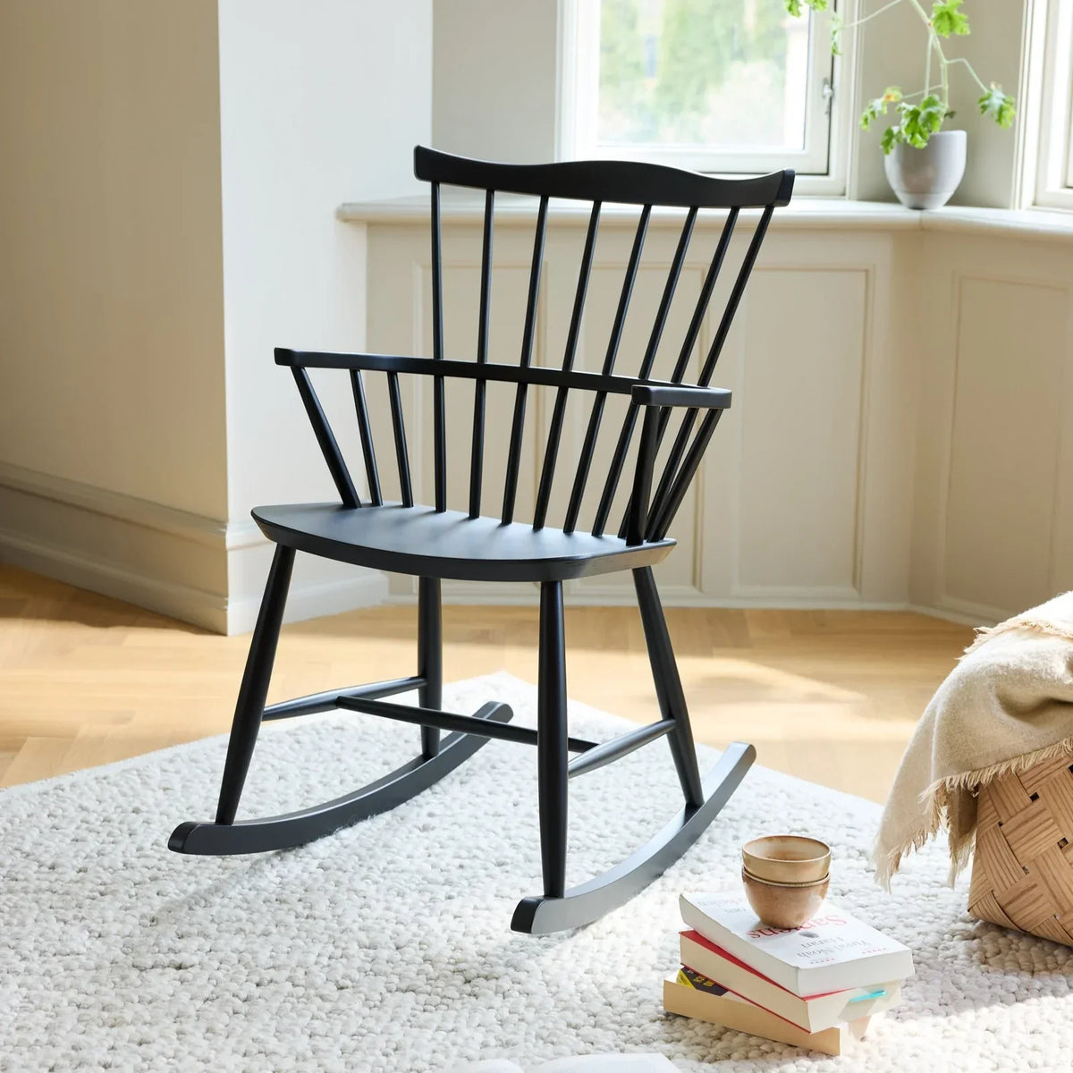 FDB Møbler J52G rocking chair by Børge Mogensen in black-painted beech on a white rug in a bright living room
