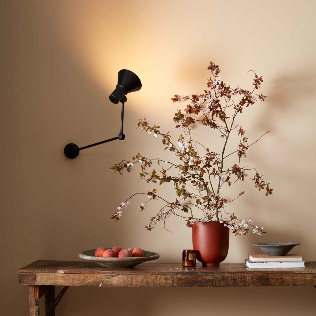 Anglepoise Type 80 W3 wall light in Matte Black above a wooden sideboard with flowers