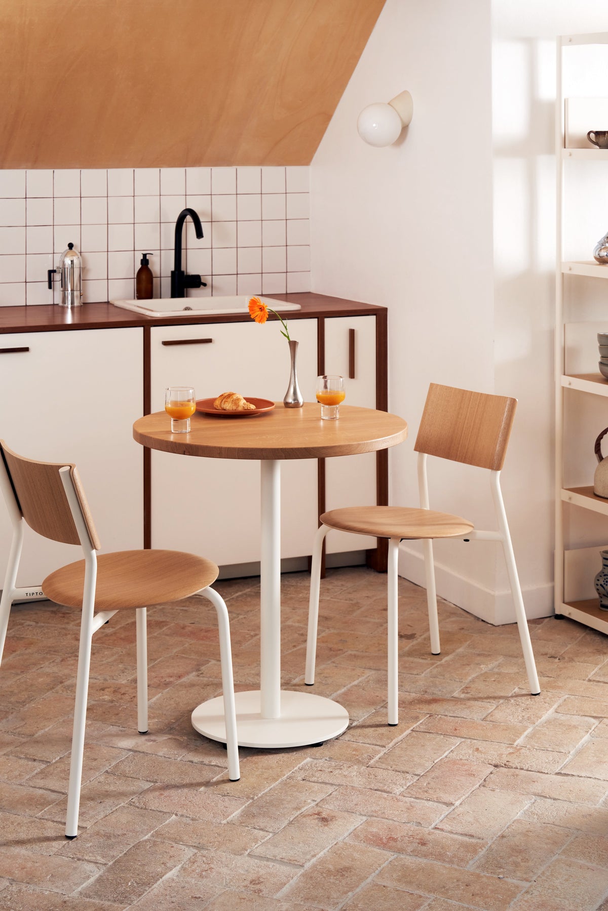 Tiptoe MOKA Bistro Table, round in Cream White, styled in a kitchen with two chairs, solid oak and steel
