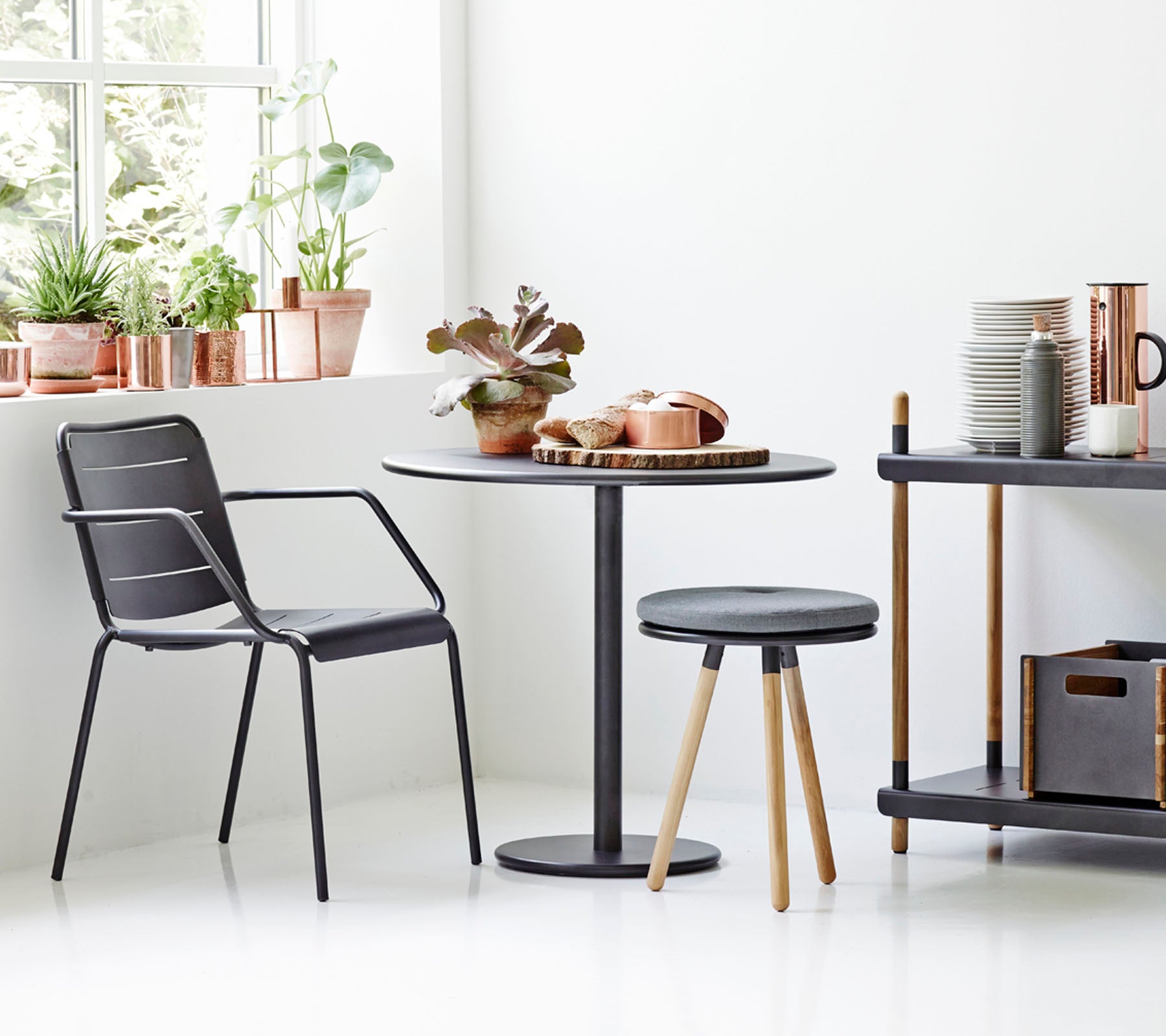 Modern dining set with black chairs and table in a bright room.