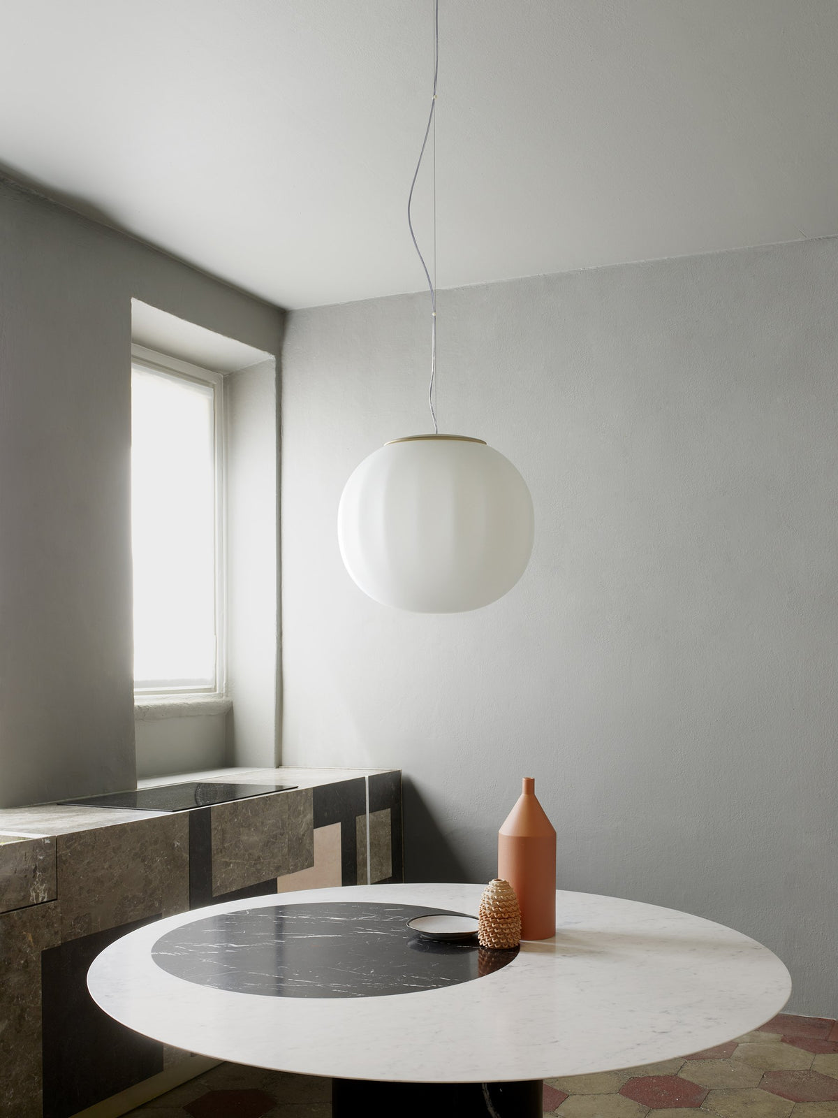 Luceplan Lita Pendant with an opal glass globe over a round table