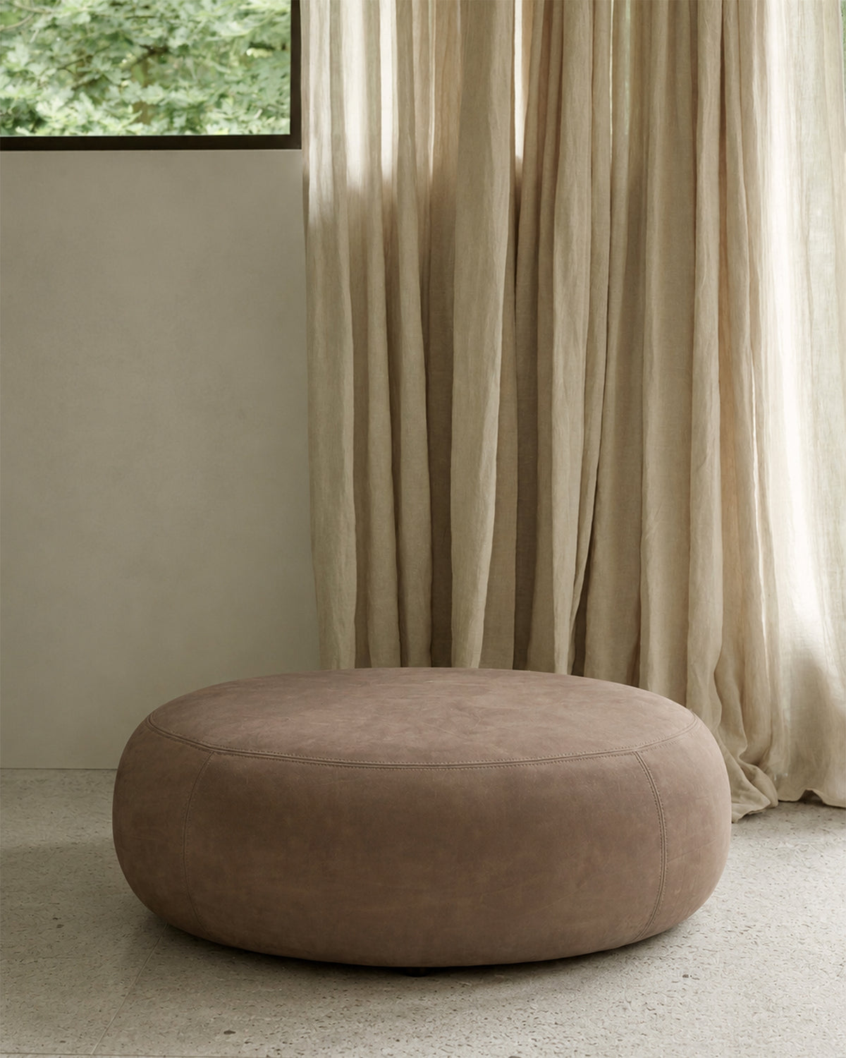 Ethnicraft Orb Pouf in Fawn, styled in a living room, full-aniline nubuck leather