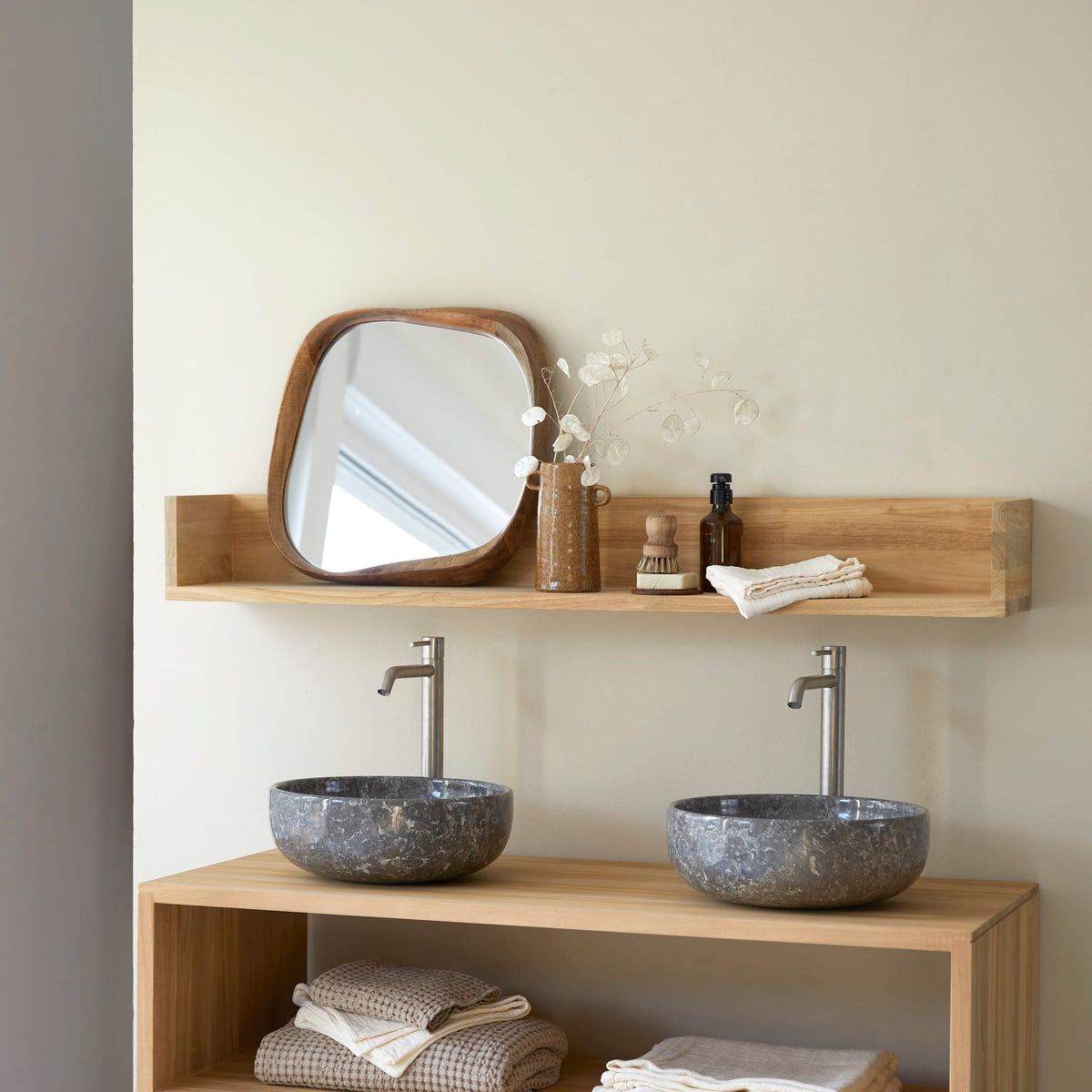 Tikamoon Arty teak wall shelf holding a mirror and bottles above two basins