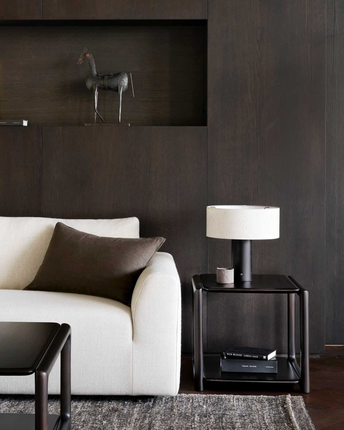 Ethnicraft Eda Side Table beside the Ease sofa, styled in an interior setting, solid mahogany
