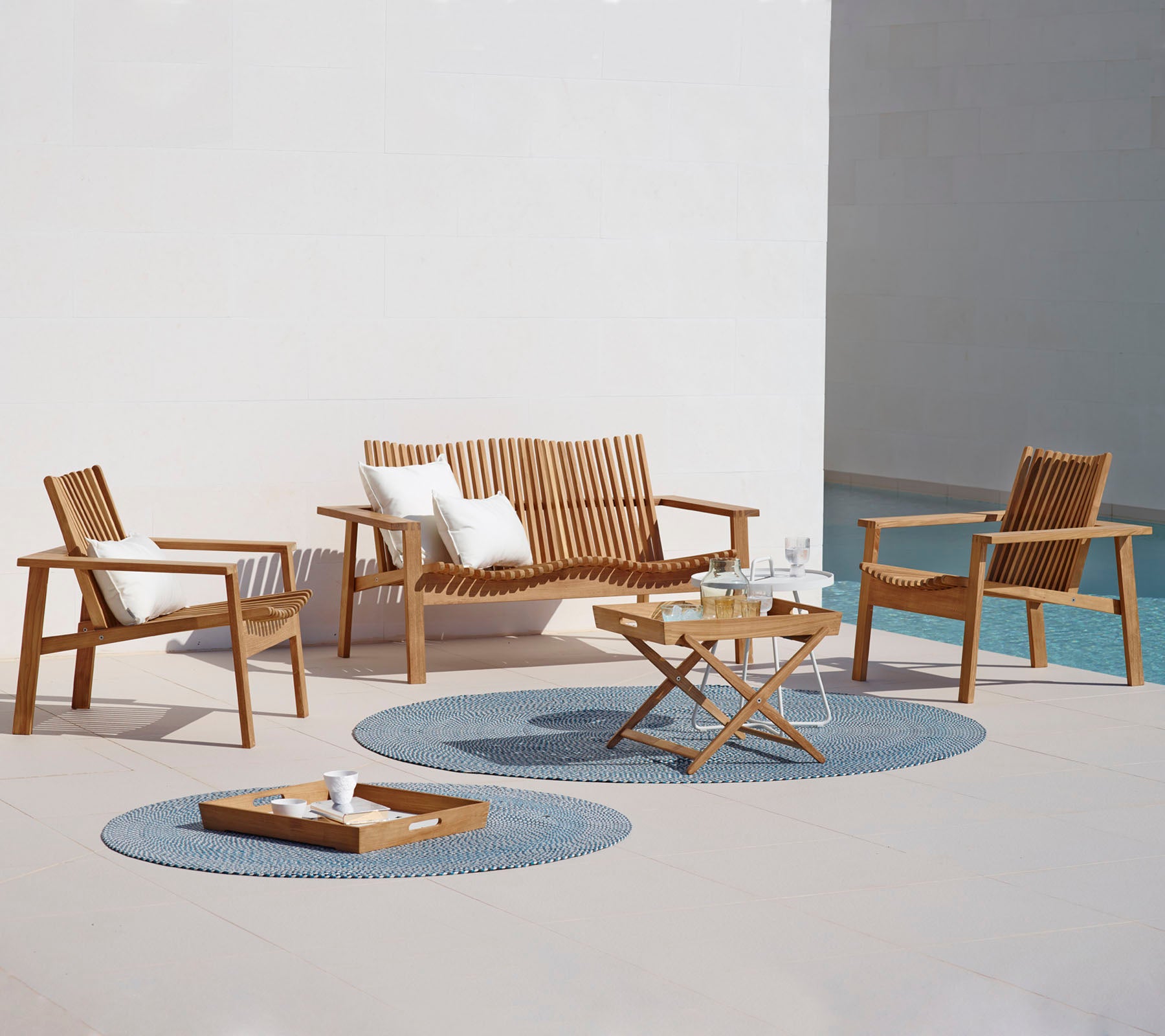 Wooden outdoor furniture set with chairs and a sofa on a patio.