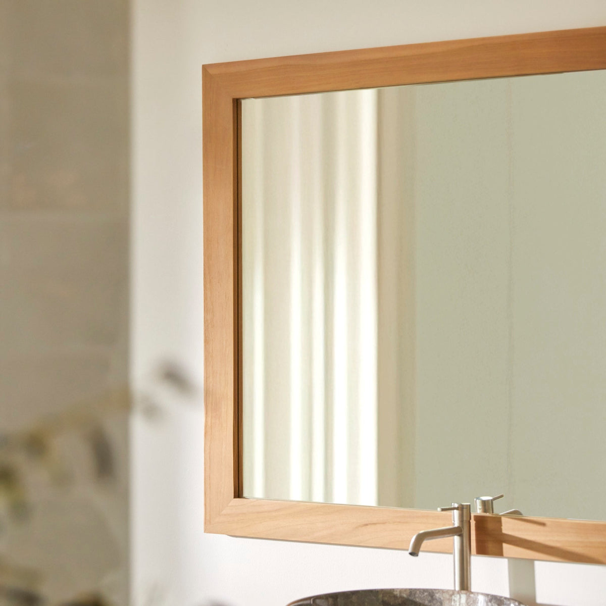 Tona mirror hung vertically beside a teak washstand