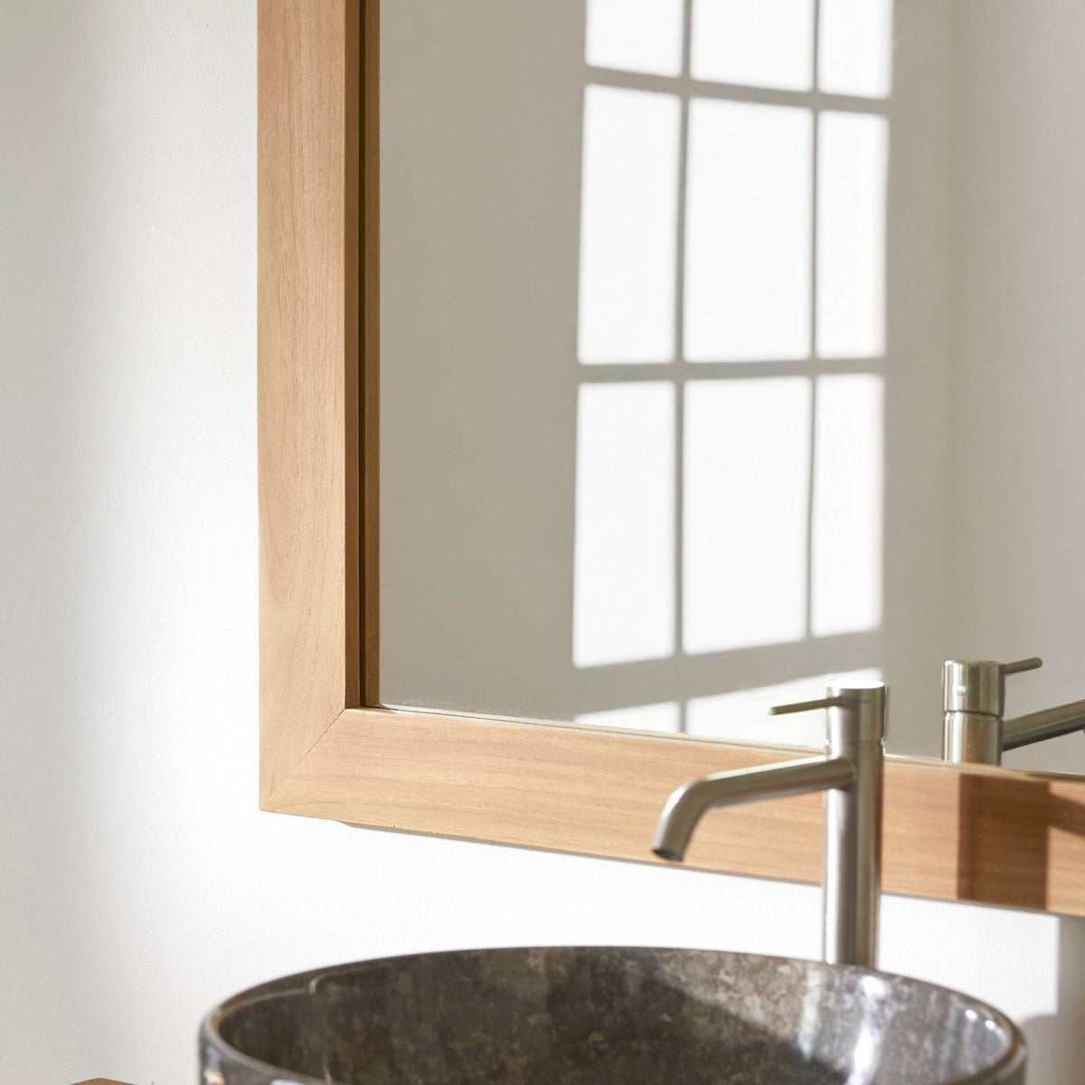 Tona mirror in a bathroom setting with teak furniture