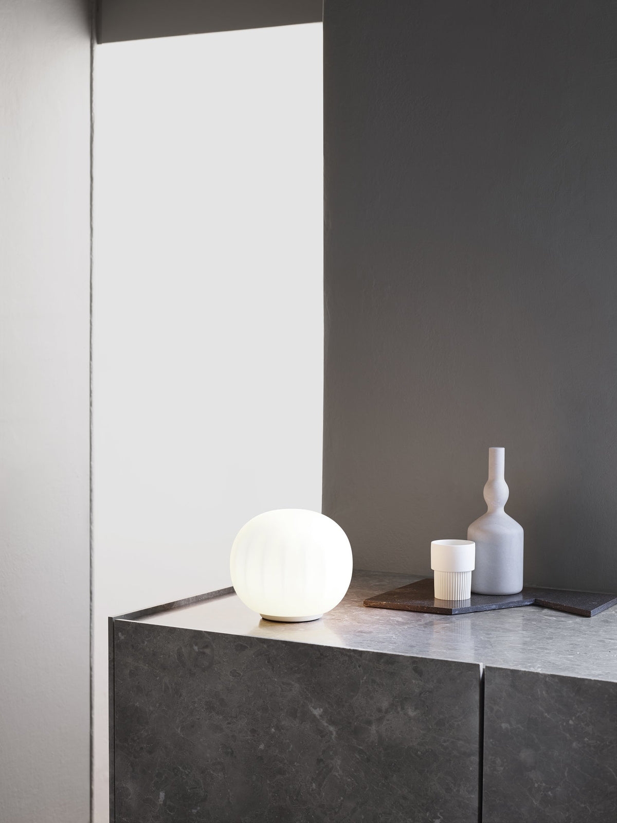 Luceplan Lita Stemless Table Lamp on a stone plinth