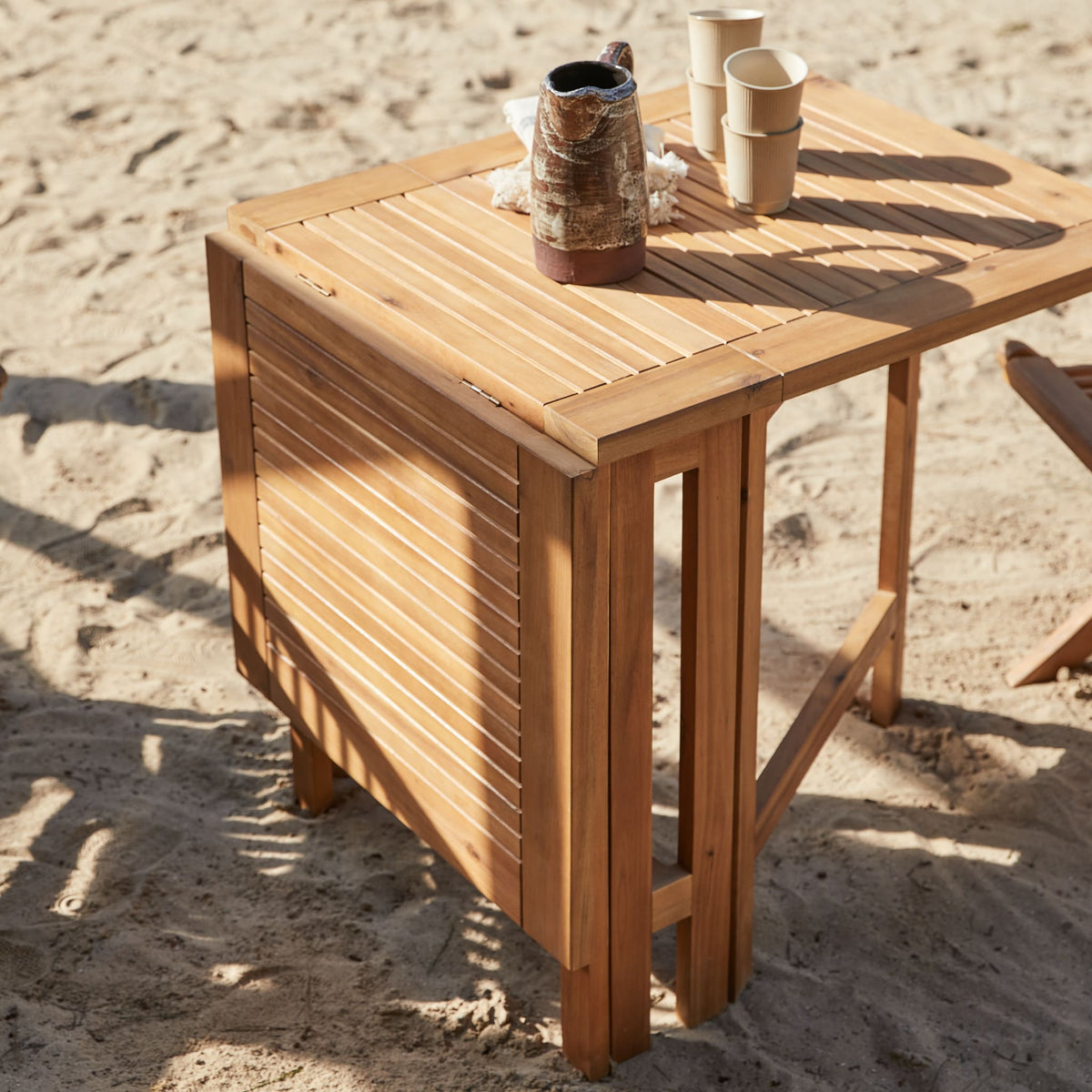 Tikamoon Capri folding garden dining set in solid acacia, close-up of a folding chair