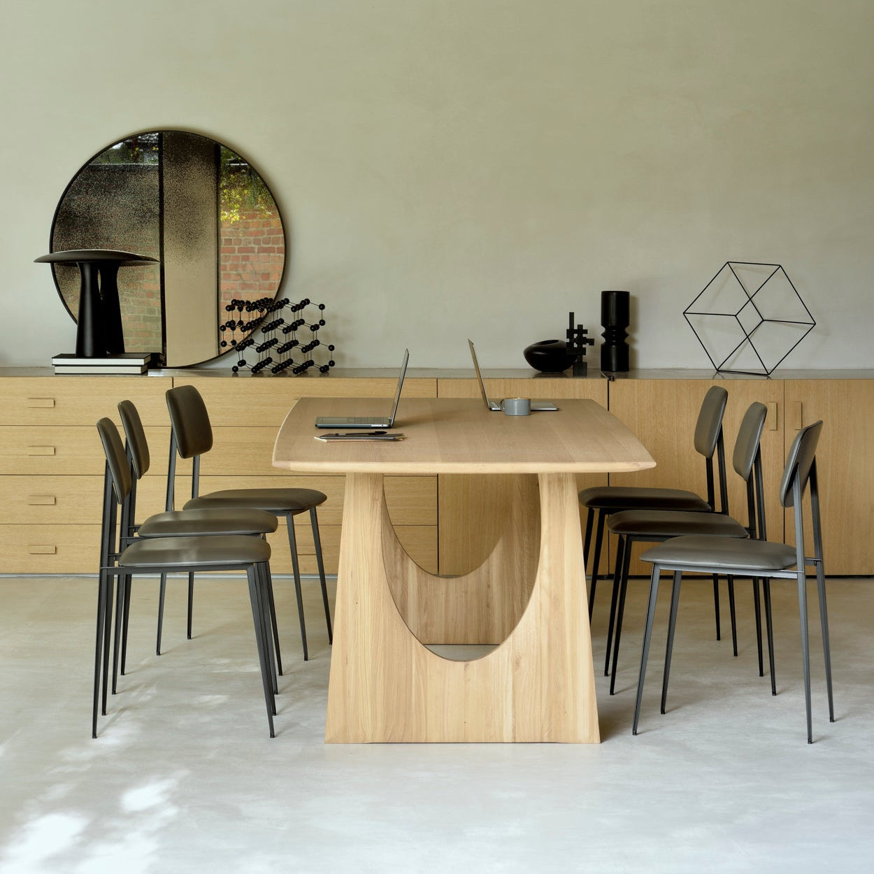Modern dining area with wooden table and chairs in a minimalistic setting.