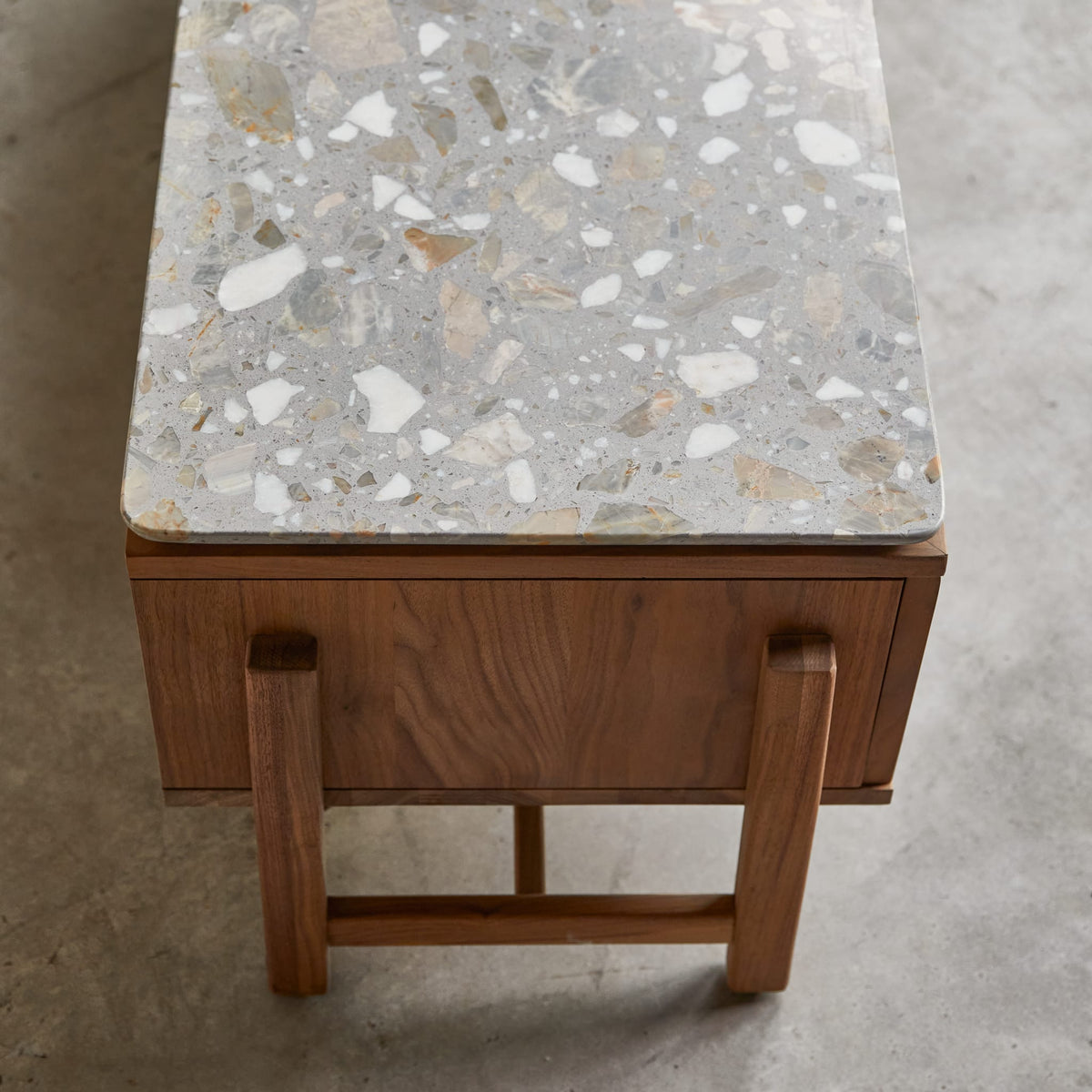 Tikamoon Isaure TV stand in solid walnut with a terrazzo top, front view