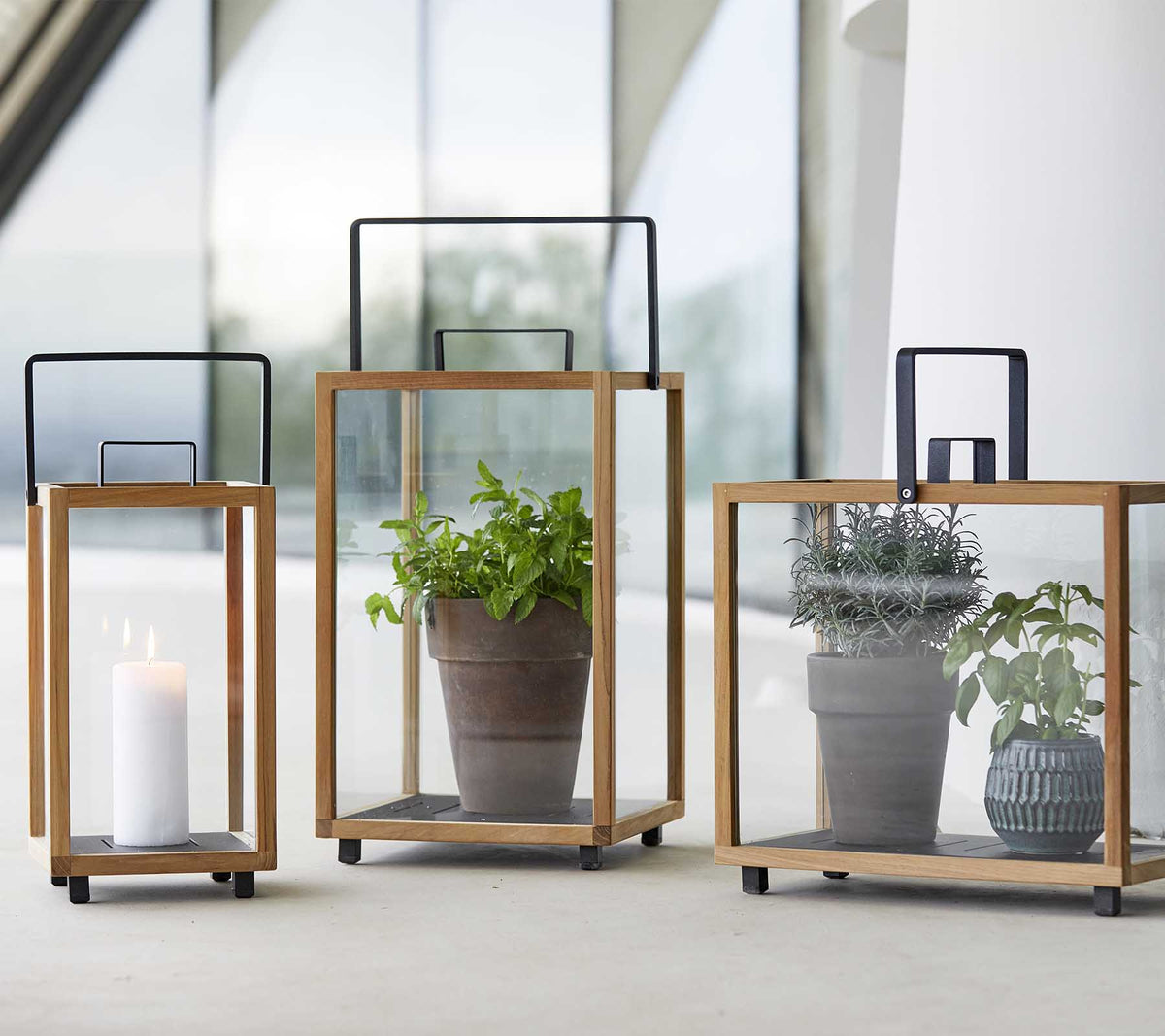 Cane-line Lighthouse Lanterns small, large and rectangular in teak with lava grey aluminum, holding a candle and plants