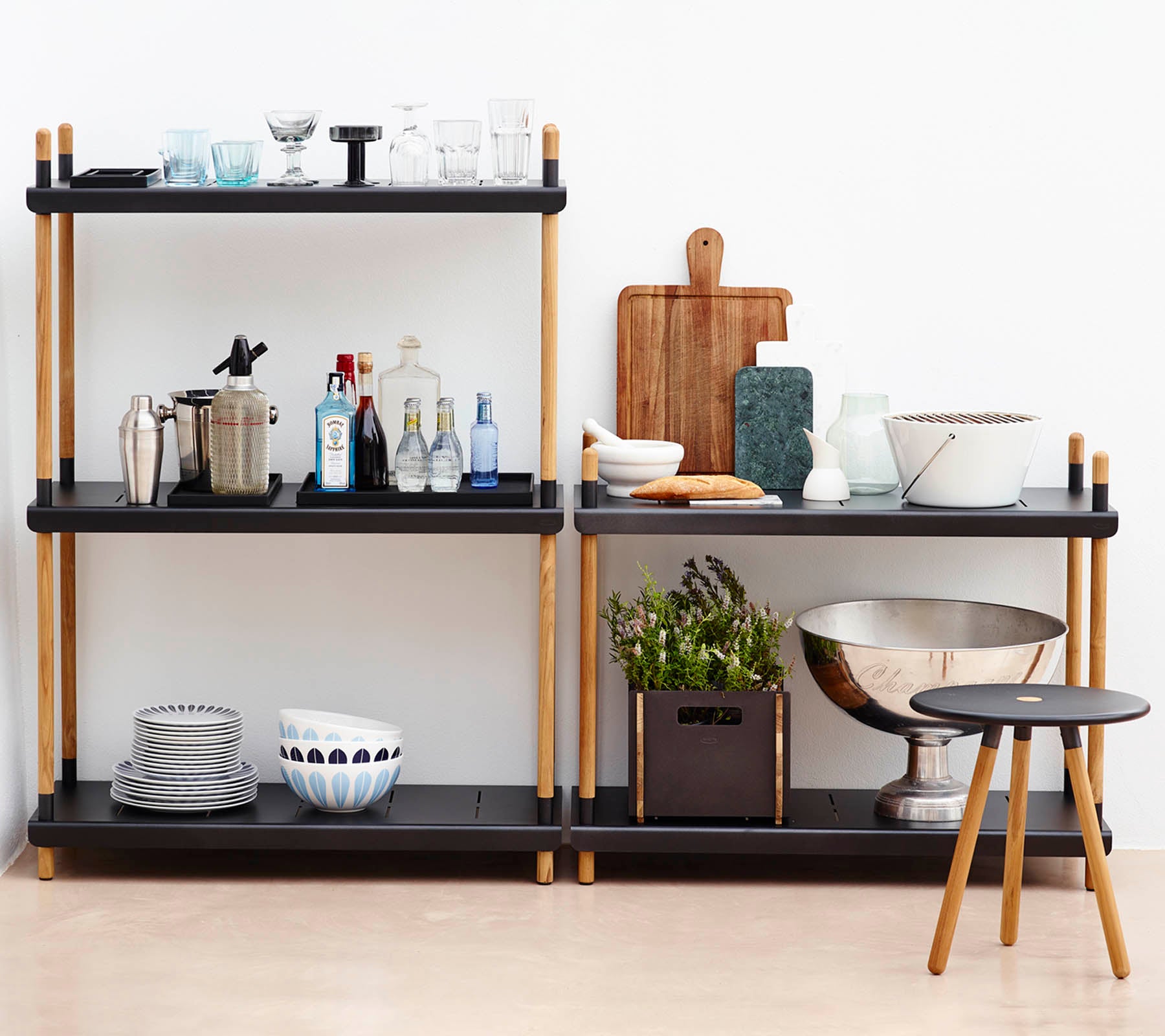 Black shelving unit with various kitchen items against a white wall