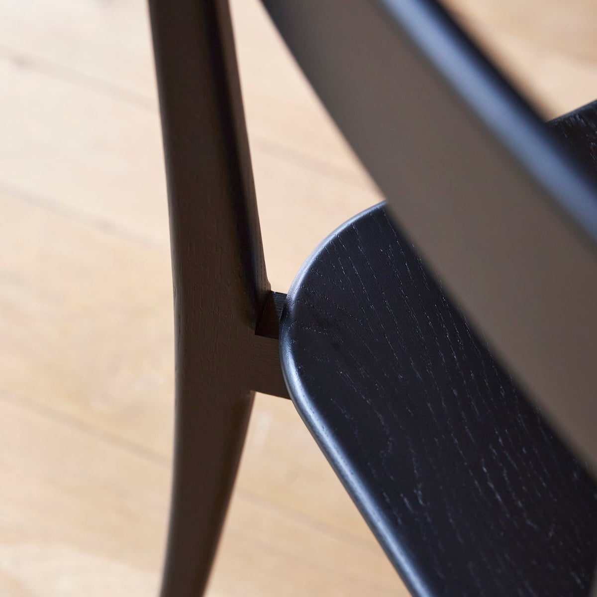 Tikamoon Abel black oak dining chair, close-up of the seat and leg detail