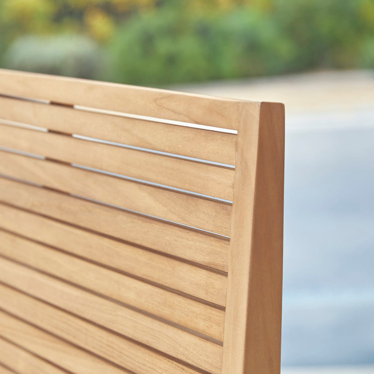 Tikamoon Teo 2-seater outdoor bench in solid teak, front view of the slatted seat and back