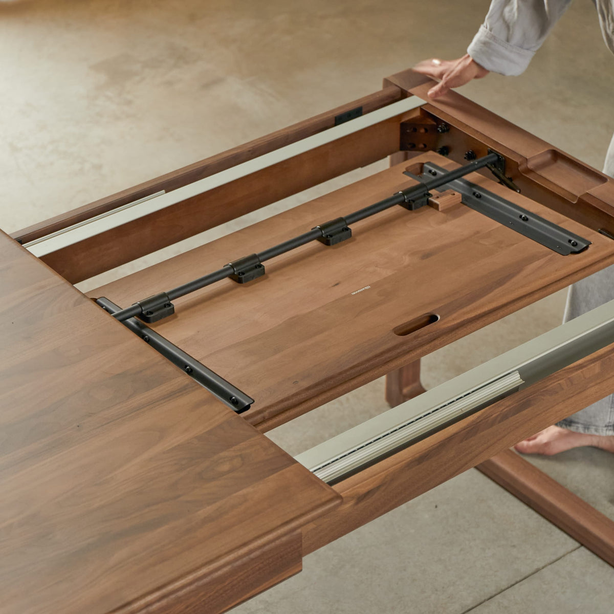 Tikamoon Arto extendable dining table in solid walnut, detail of a leg