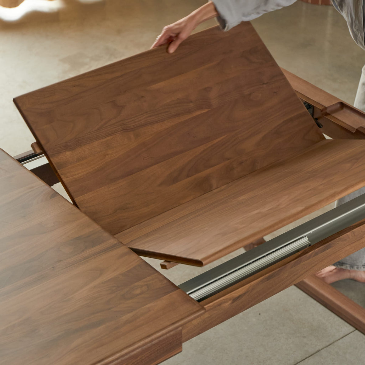 Tikamoon Arto extendable dining table in solid walnut, detail of the underframe