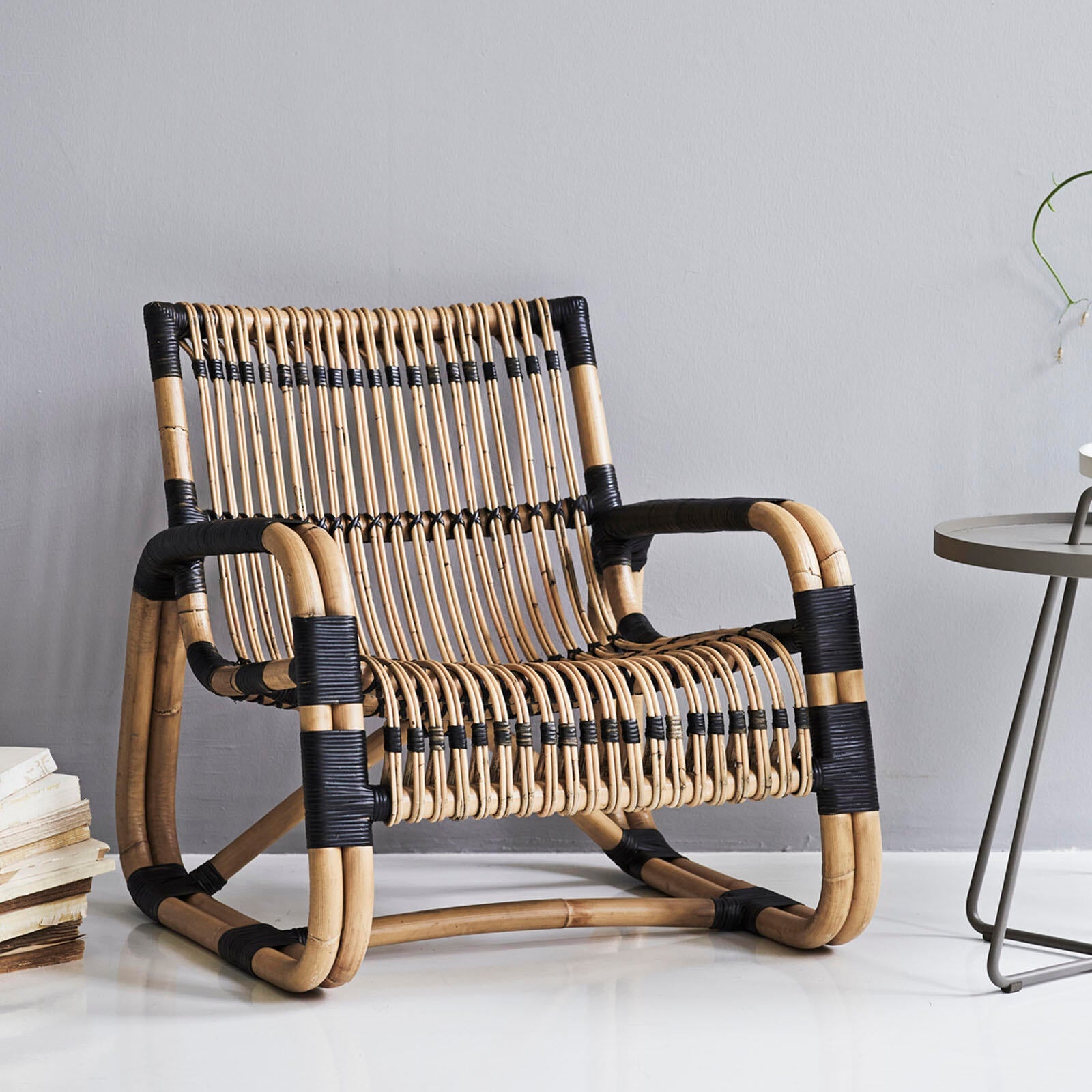 Wicker chair with black accents in a minimalistic room.