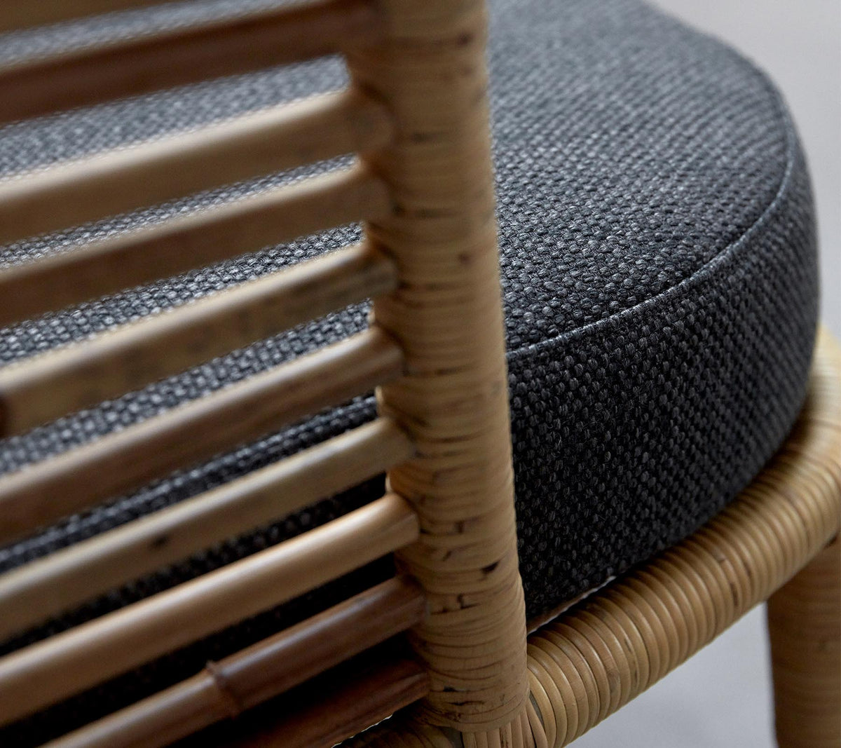 Detail of Cane-line Sense Lounge Chair showing handmade natural rattan sticks and seat cushion