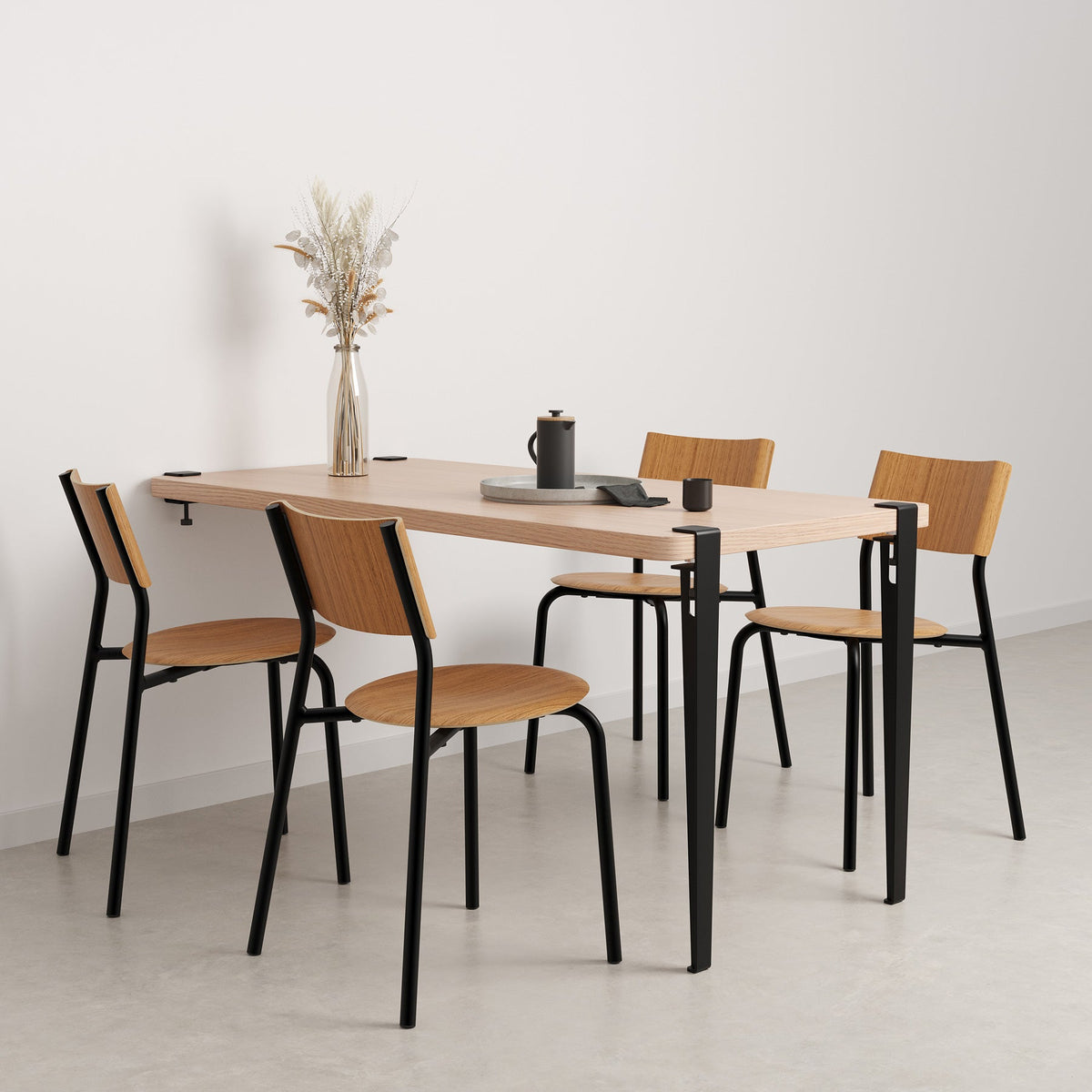 Tiptoe Wall Desk 150 x 75 cm in Graphite Black, styled as a dining table with chairs, oak veneer and steel