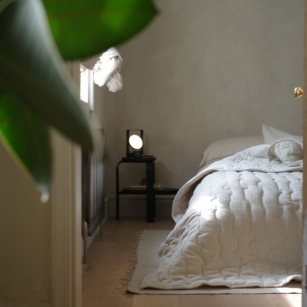 Case Ripple quilt in off-white on a bed in a sunlit bedroom