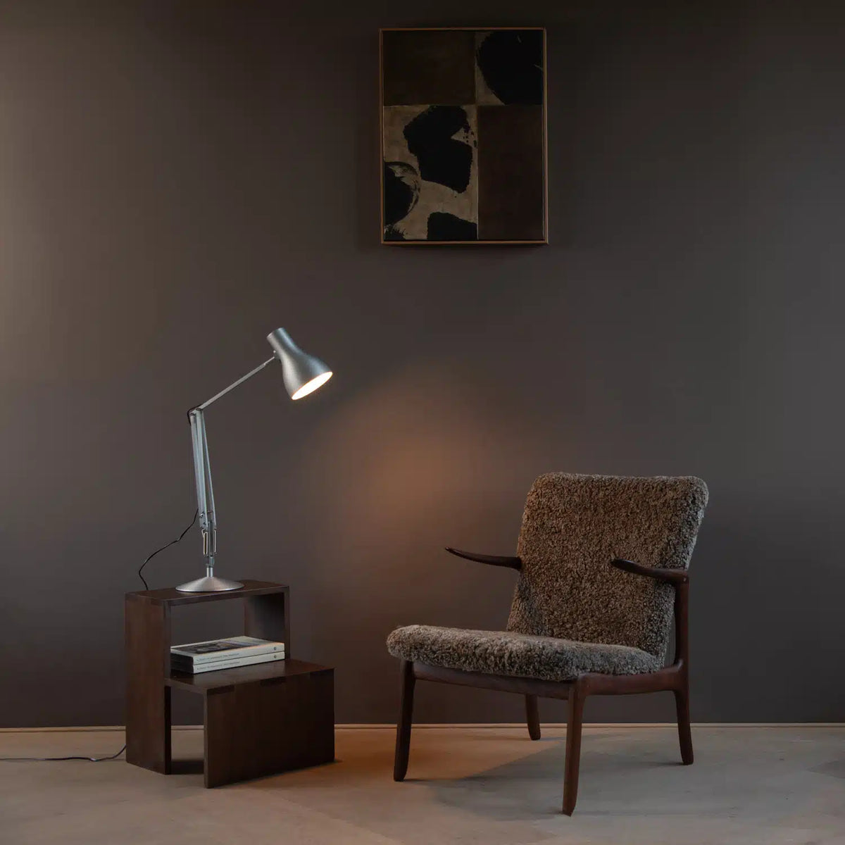 Anglepoise Type 75 desk lamp in a silver finish on a side table next to a shearling lounge chair