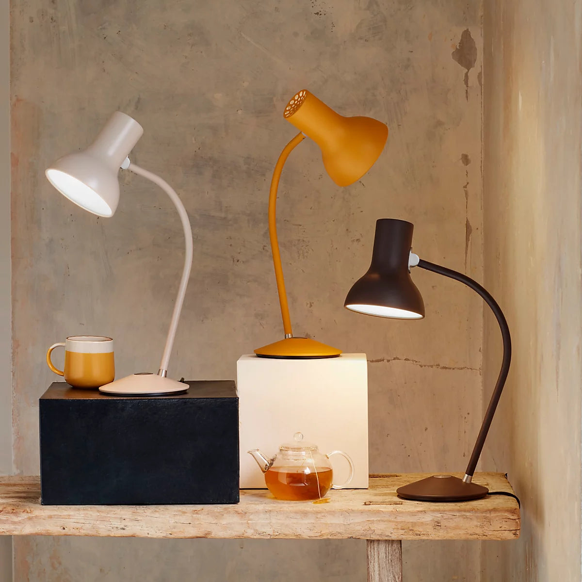 Anglepoise Type 75 Mini table lamps in Mole Gray, Turmeric Gold and Black Umber on a wooden shelf