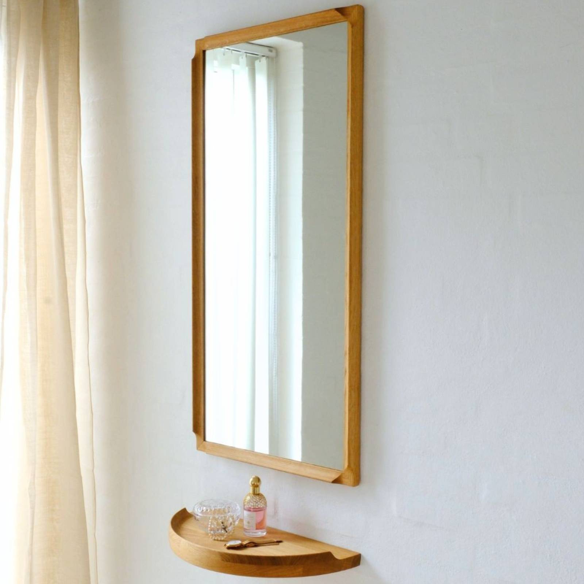 Aakjaer Arcus Mirror in natural oiled oak hung above an Arcus Console Shelf in a hallway