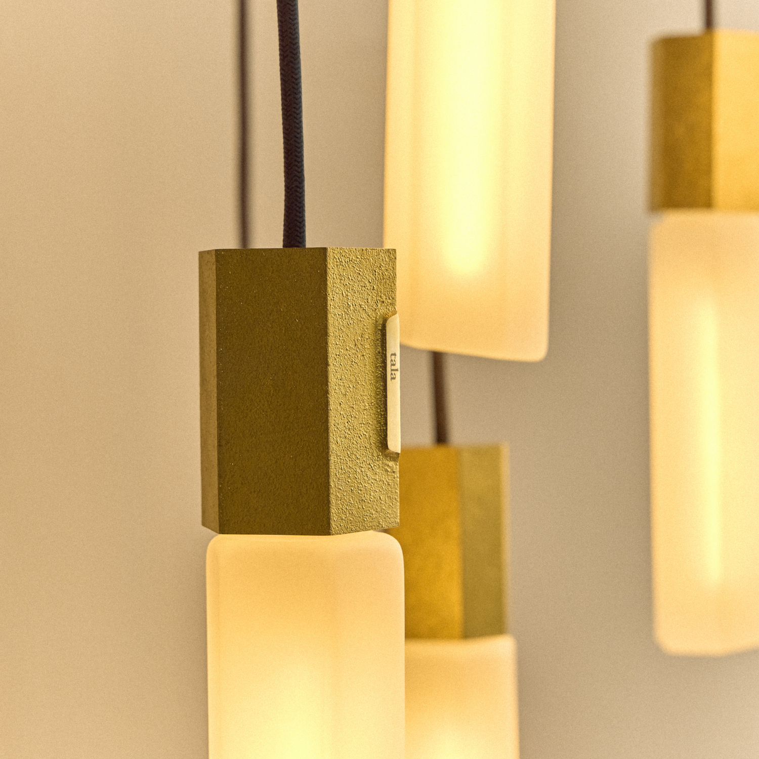 Basalt Nine Pendant by Tala in Brass, wide view of the nine hexagonal glass bulbs lit