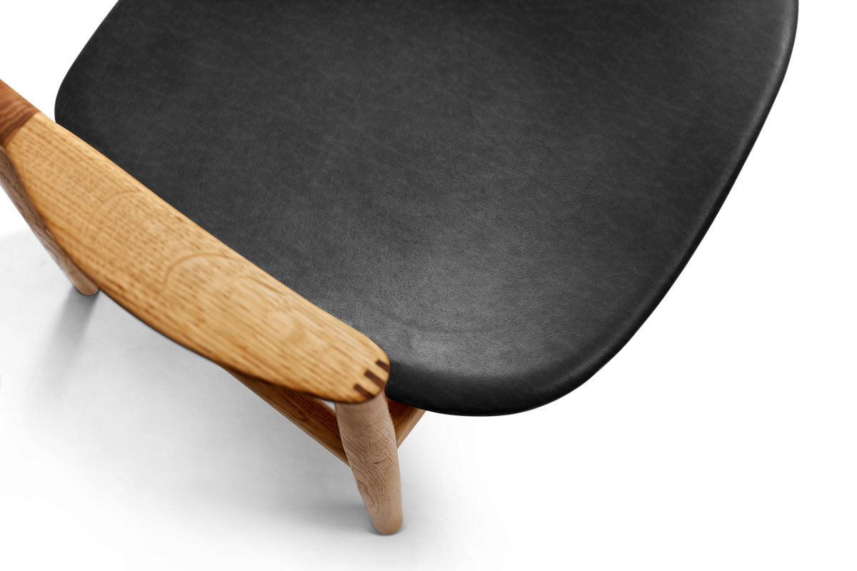 Detail of Bent Hansen Asger Dining Chair showing the black leather seat corner