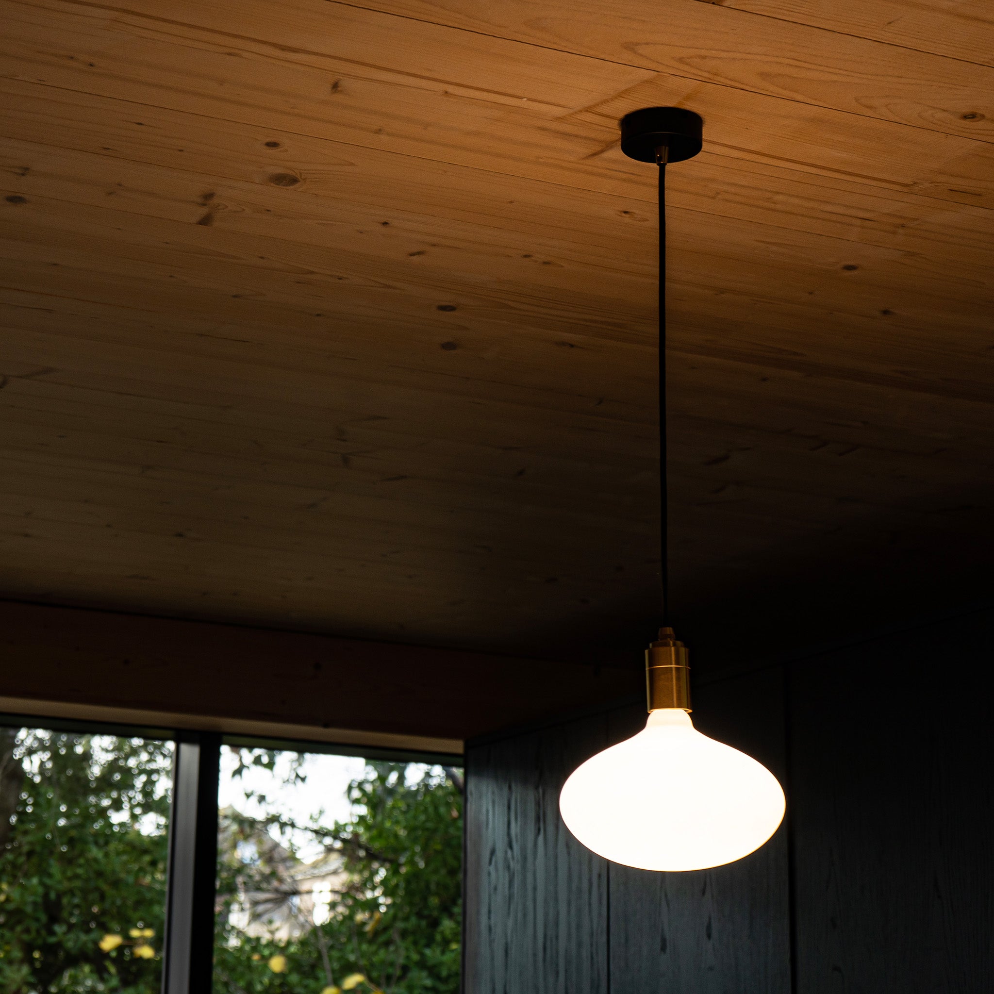 Oval II Pendant Light by Tala — lifestyle setting, woven chair, graphite