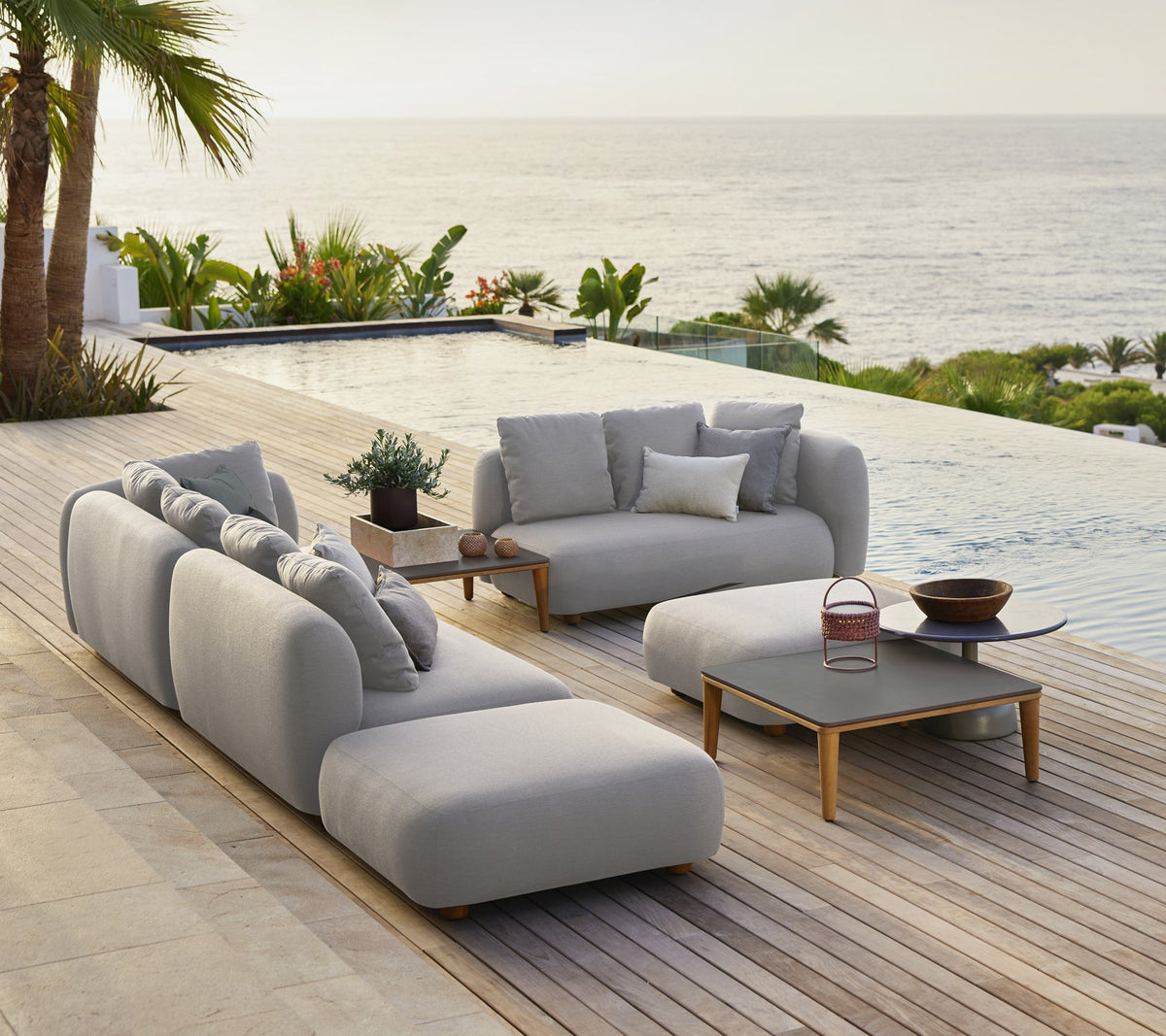 Cane-line Capture lounge in light grey AirTouch acrylic with a Capture coffee table, styled on a seaside terrace