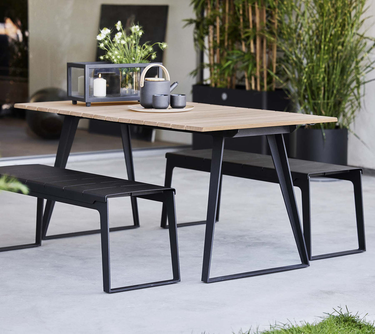 Cane-line Copenhagen Extendable Dining Table with matching benches, styled outdoors, teak and aluminum