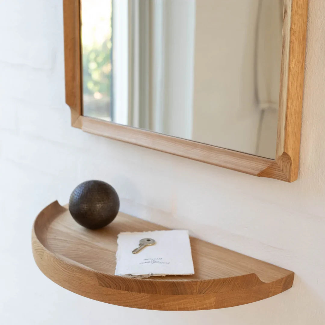Aakjaer Arcus Mirror above an Arcus Console Shelf holding a key and a dark round ornament
