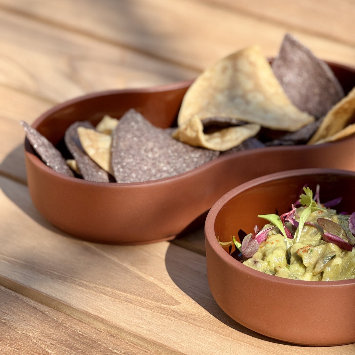 Case Dip Bowl in Brown, styled on an outdoor teak table, solid-colored porcelain