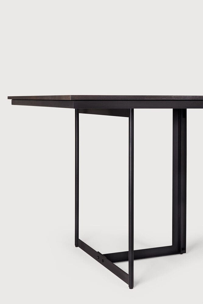 Detail of Ethnicraft Tacet Dining Table showing the black metal leg frame under the teak top