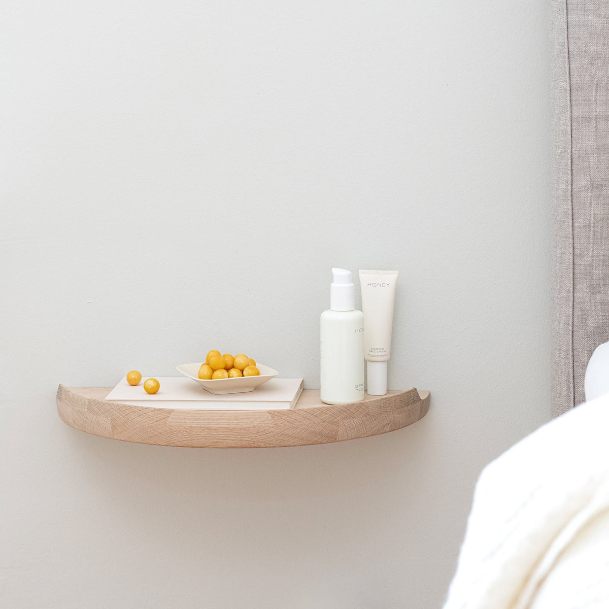 Aakjaer Arcus Console Shelf in white oiled oak used as a floating bedside table