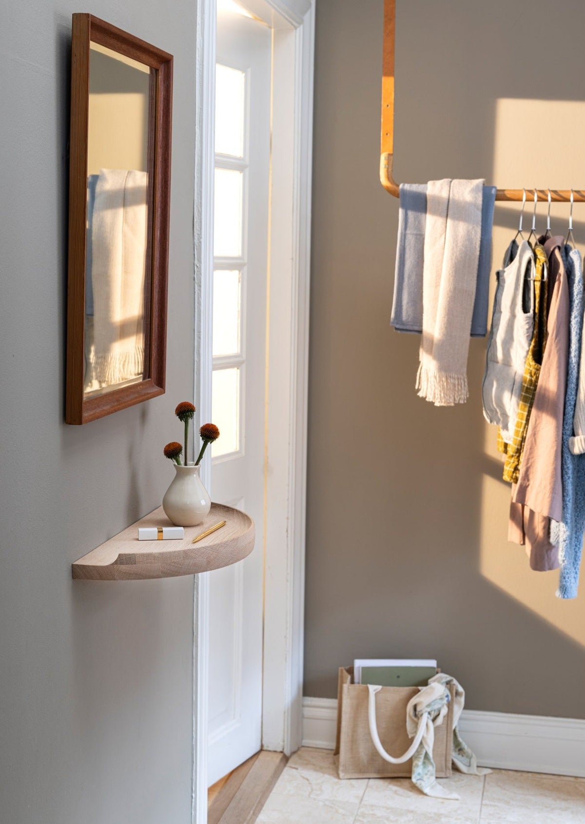 Aakjaer Arcus Console Shelf in white oiled oak in a hallway with a mirror and a clothes rail