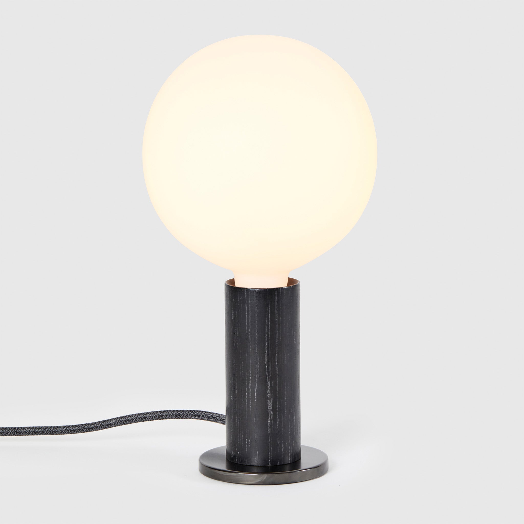 Knuckle Table Lamp in Blackened Oak with Sphere bulb, illuminated