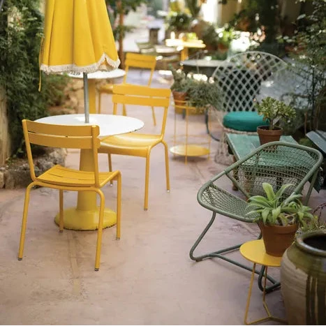 Fermob Luxembourg Side Chair in Honey styled in a Mediterranean setting, the Luxembourg garden chair