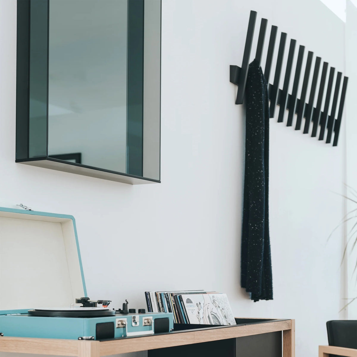 Case Lucent mirror in Smoke Glass beside a black coat hook