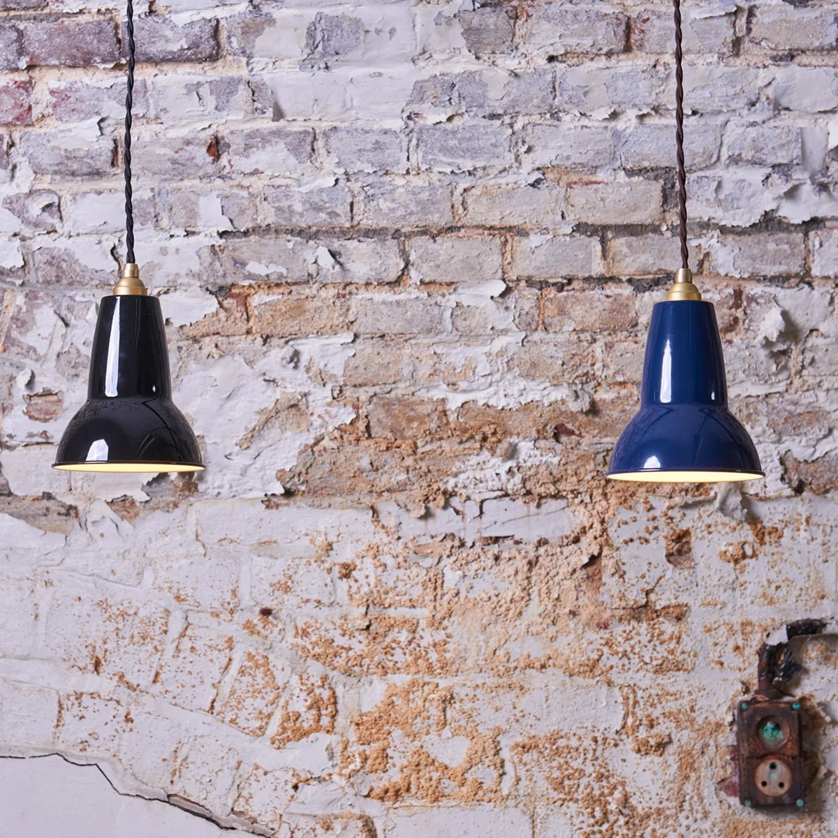 Anglepoise Original 1227 pendants in Jet Black and blue against a weathered brick wall