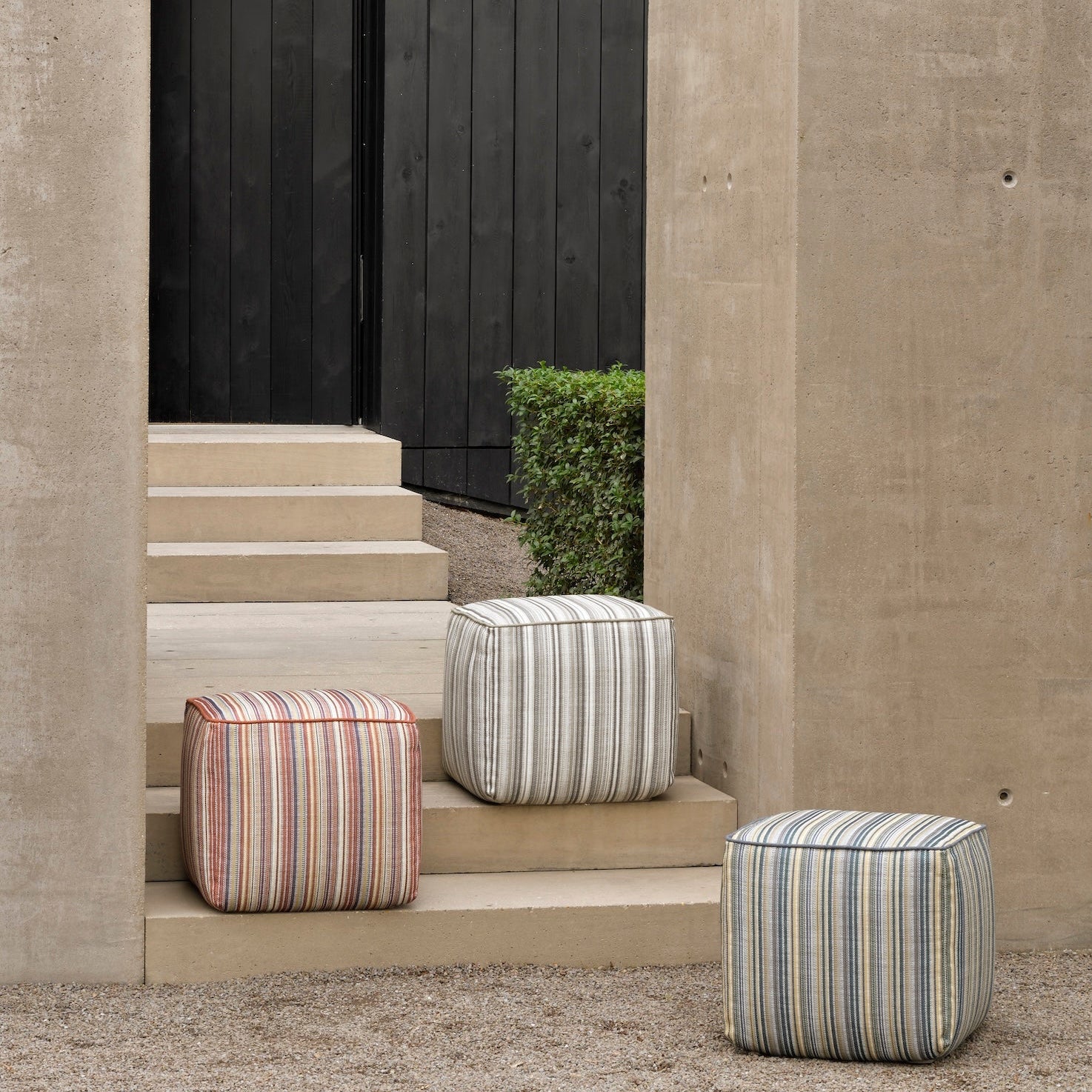 Striped ottomans on a concrete staircase with a modern building in the background