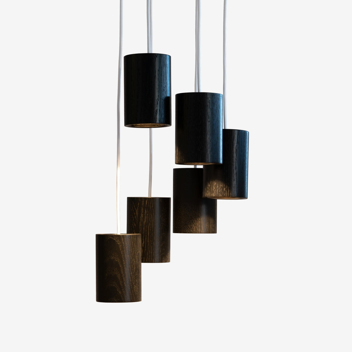 Case Solid Six Pendant Cluster in Black Stained Oak, staggered cylinders, black stained solid oak